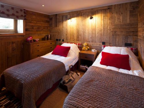deux lits dans une chambre aux murs en bois dans l'établissement Chalet 5 chambres, Sauna, Bain Norvégien, Wifi, 12 pers. à La Clusaz - FR-1-437-57, à La Clusaz
