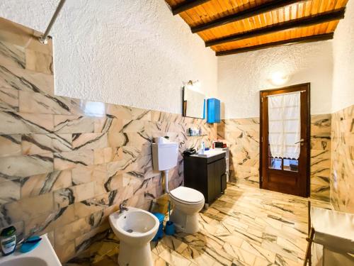 Baño de piedra con aseo y lavamanos en Casa Terra, en Burgau