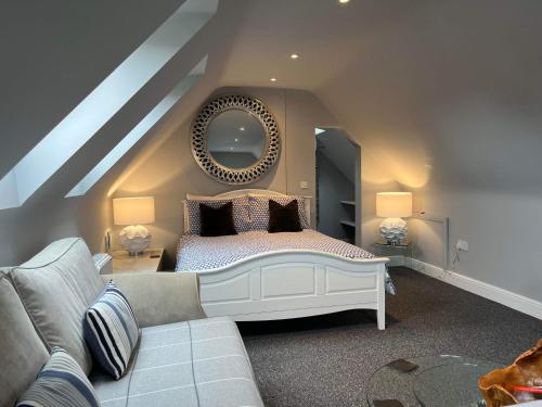 um quarto com uma cama com um espelho e um sofá em The Coquet Apartment - short stroll to Warkworth Castle and Hermitage em Warkworth