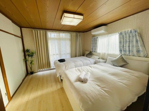 a small room with two beds and a window at Nishi-Shinjuku 3LDK SJ0243 in Tokyo
