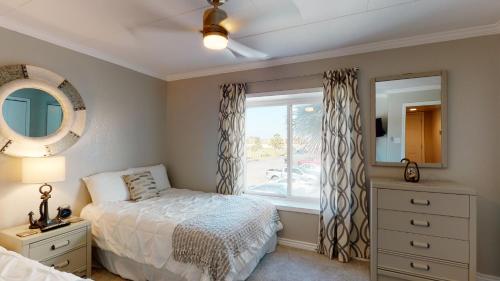 a bedroom with a bed and a window and a mirror at IR145 2nd Floor Condo, Ocean View, 1 Bedroom, Shared Pools, Boardwalks in Port Aransas