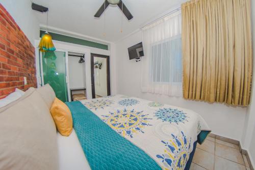 a bedroom with a bed and a window at Hotel Suites Nadia Puerto Vallarta in Puerto Vallarta