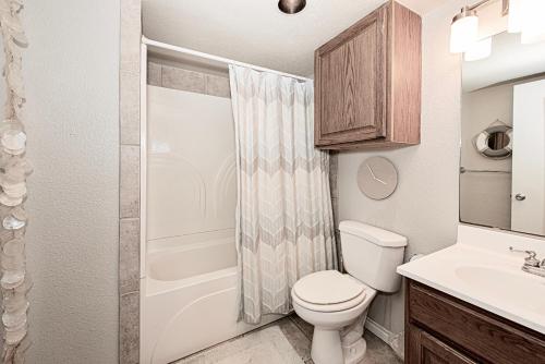 a bathroom with a toilet and a sink and a shower at IR149 2nd Floor Studio Condo with Gulf View, Shared Pools, Boardwalks in Port Aransas