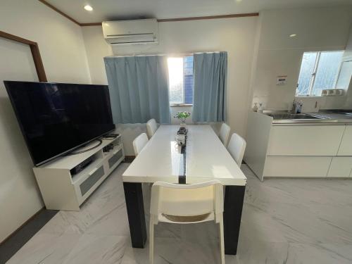 a living room with a white table and a television at Nishi-Shinjuku 3LDK SJ0243 in Tokyo