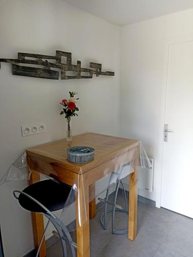 a wooden table with a vase of flowers on it at La Clematite d'Olt in Saint-Côme-dʼOlt