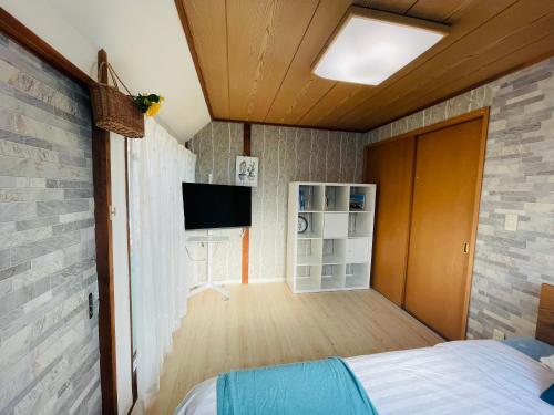 a bedroom with a bed and a tv on a brick wall at Nishi-Shinjuku 3LDK SJ0243 in Tokyo