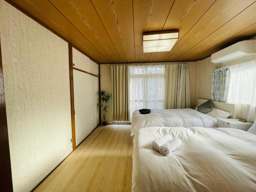 a hotel room with two beds and a window at Nishi-Shinjuku 3LDK SJ0243 in Tokyo