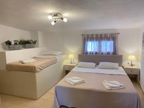 1 dormitorio con 2 camas y ventana en PORT SEA VIEW - SKIATHOS, en Skiathos