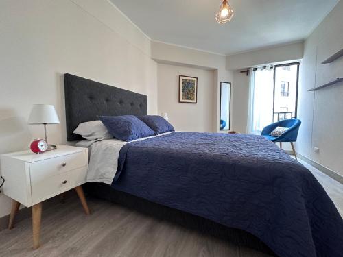 een slaapkamer met een groot bed en een blauw dekbed bij HC San Isidro Apartment in Lima