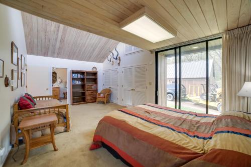 Schlafzimmer mit einem Bett, einem Schreibtisch und einem Fenster in der Unterkunft Spacious Plymouth Hideaway on Acreage with Lake! in Plymouth