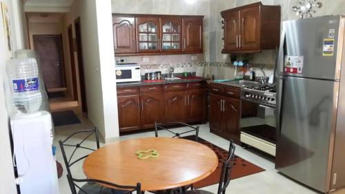 a kitchen with a wooden table and a refrigerator at La Vista 6 Ain Sokhna Chaleh in Ain Sokhna