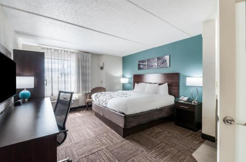 a hotel room with a bed and a desk at Sleep Inn & Suites Rehoboth Beach in Rehoboth Beach