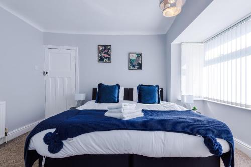 a blue and white bedroom with a large bed at Charming 3-Bedroom Home in Liverpool - FREE Parking in Deysbrook