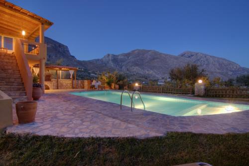 a swimming pool at night with mountains in the background at Villa Despina 1 Plakias Private Villa, Private Swimming Pool Garden,Amazing View in Lefkogeia