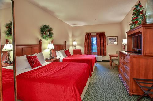 a hotel room with two beds and a christmas tree at The Inn at Christmas Place in Pigeon Forge