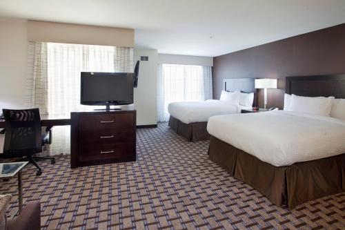 a hotel room with two beds and a flat screen tv at Residence Inn Odessa in Odessa