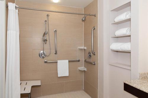a bathroom with a shower with a toilet and towels at Residence Inn Odessa in Odessa