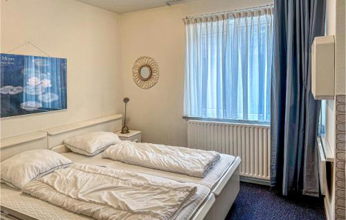 ein kleines Schlafzimmer mit einem Bett und einem Fenster in der Unterkunft Duinennest in Bergen aan Zee