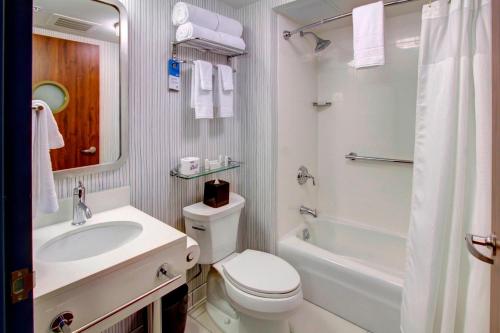 Baño blanco con aseo y lavamanos en Fairfield Inn by Marriott New York Manhattan/Financial District, en Nueva York