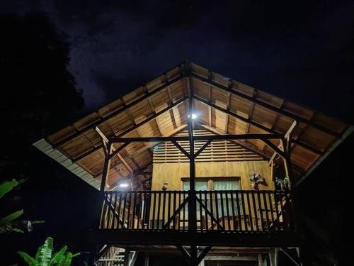 a tree house with a balcony at night at Mama Yeya raíces in San Cipriano