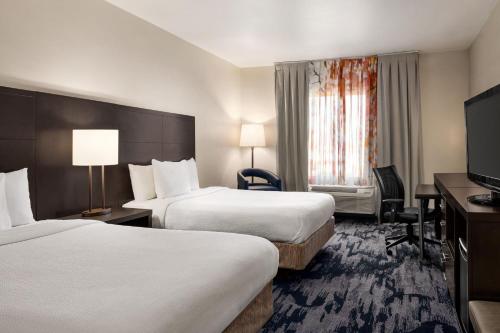 a hotel room with two beds and a flat screen tv at Fairfield Inn & Suites by Marriott Amarillo Airport in Amarillo