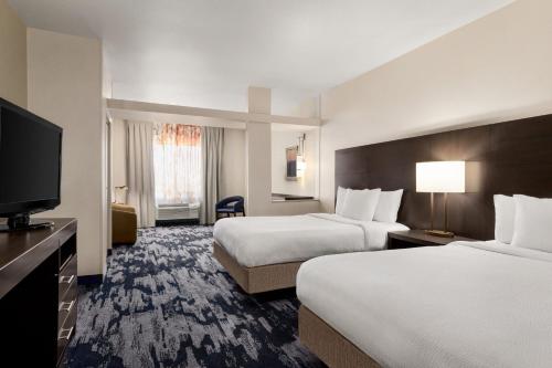 a hotel room with two beds and a flat screen tv at Fairfield Inn & Suites by Marriott Amarillo Airport in Amarillo