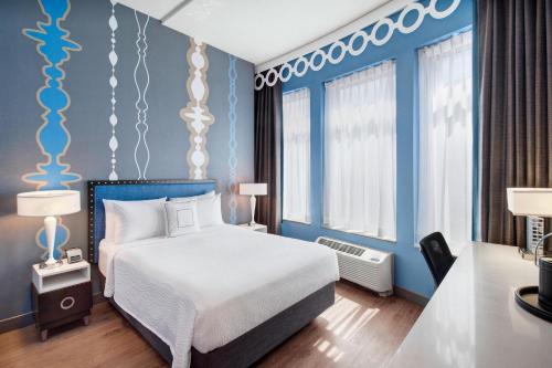 Schlafzimmer mit einem Bett und blauen Wänden in der Unterkunft Fairfield Inn and Suites Chicago Downtown/ Magnificent Mile in Chicago