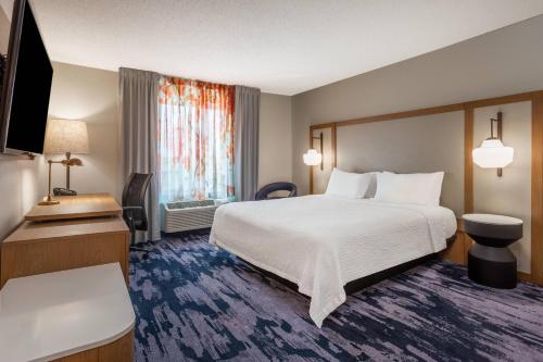 una camera d'albergo con un grande letto e una TV di Fairfield Inn & Suites Indianapolis Northwest a Indianapolis