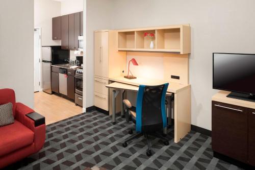 a small office with a desk and a red chair at TownePlace Suites Columbus in Columbus