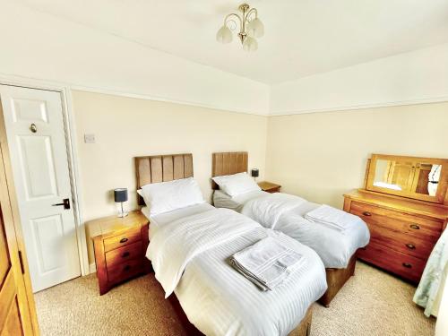 a bedroom with two beds and a mirror at Bay View Apartment - Trearddur Bay in Trearddur