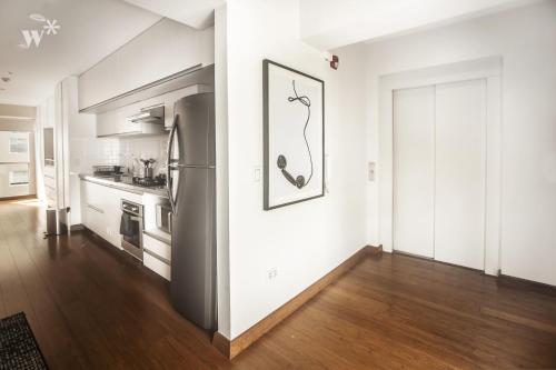 a kitchen with white walls and a refrigerator at Las Mimosas by Wynwood House in Lima