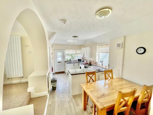 una cucina e una sala da pranzo con tavolo in legno di Bay View Apartment - Trearddur Bay a Trearddur