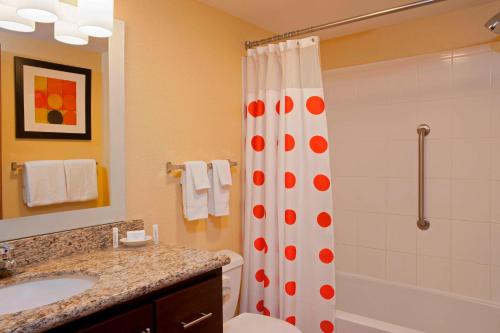 a bathroom with a shower and a toilet and a sink at TownePlace Suites by Marriott Bloomington in Bloomington
