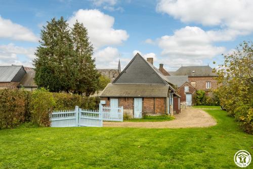 a house with a white fence and a yard at Le Logis Bleu in Senantes
