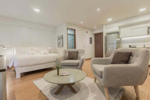 a bedroom with a bed and two chairs and a table at Las Mimosas by Wynwood House in Lima