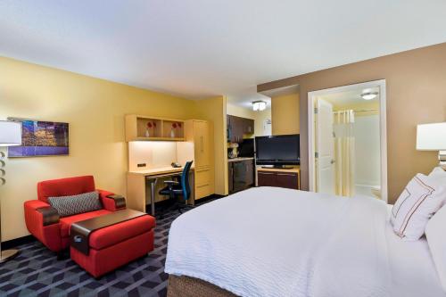 a hotel room with a bed and a chair and a desk at TownePlace Suites Pensacola in Pensacola