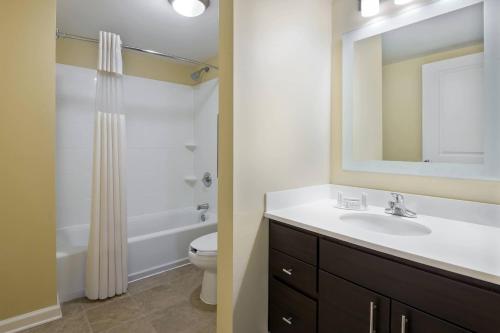 a bathroom with a sink and a toilet and a mirror at TownePlace Suites Pensacola in Pensacola