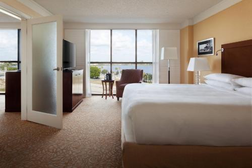 a hotel room with a large bed and a television at West Palm Beach Marriott in West Palm Beach
