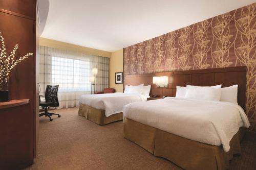 a hotel room with two beds and a desk at Courtyard by Marriott Salisbury in Salisbury