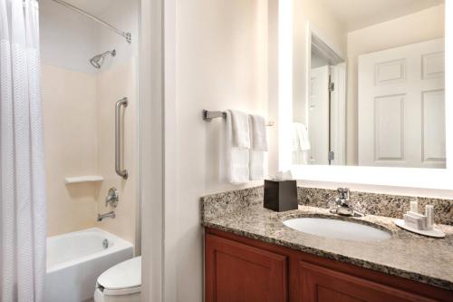 a bathroom with a sink and a toilet and a mirror at TownePlace Suites Fort Lauderdale West in Fort Lauderdale