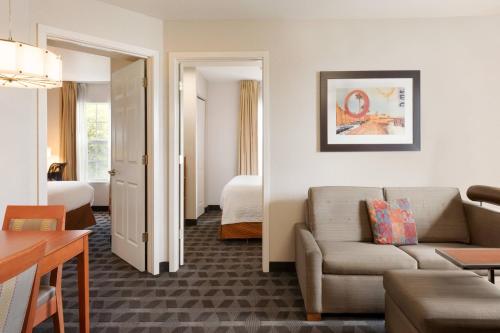 TownePlace Suites Fort Lauderdale West في فورت لاودردال: غرفة معيشة مع أريكة وغرفة نوم