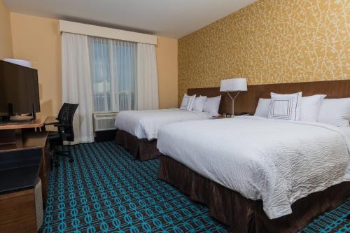 a hotel room with two beds and a flat screen tv at Fairfield Inn & Suites by Marriott Florence I-20 in Florence