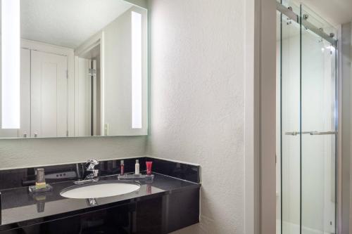 La salle de bains est pourvue d'un lavabo et d'un miroir. dans l'établissement Fort Lauderdale Marriott North, à Fort Lauderdale