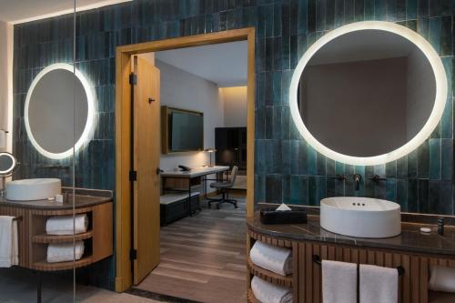 a bathroom with two sinks and a mirror at Courtyard by Marriott Santo Domingo in Santo Domingo