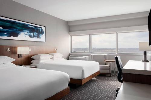 una camera d'albergo con 2 letti e una scrivania di Delta Hotels by Marriott Woodbridge a Iselin