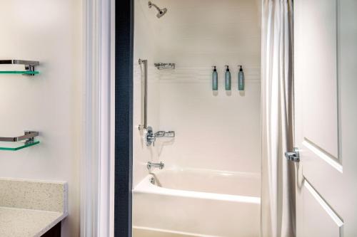 La salle de bains blanche est pourvue d'une baignoire et d'une douche. dans l'établissement Residence Inn by Marriott Boston Cambridge, à Cambridge