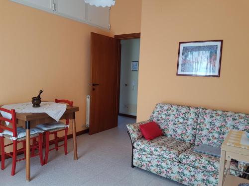 een woonkamer met een bank en een tafel bij La casa delle rose in Su Forti