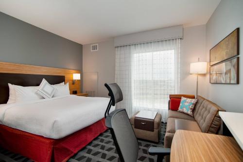 TownePlace Suites Fort Worth University Area/Medical Center في فورت وورث: غرفه فندقيه بسرير واريكه