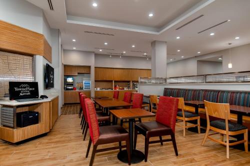 a restaurant with wooden tables and red chairs at TownePlace Suites Fort Worth University Area/Medical Center in Fort Worth