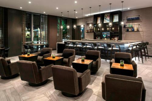 a restaurant with tables and chairs and a bar at AC Hotel by Marriott Boston Cleveland Circle in Boston